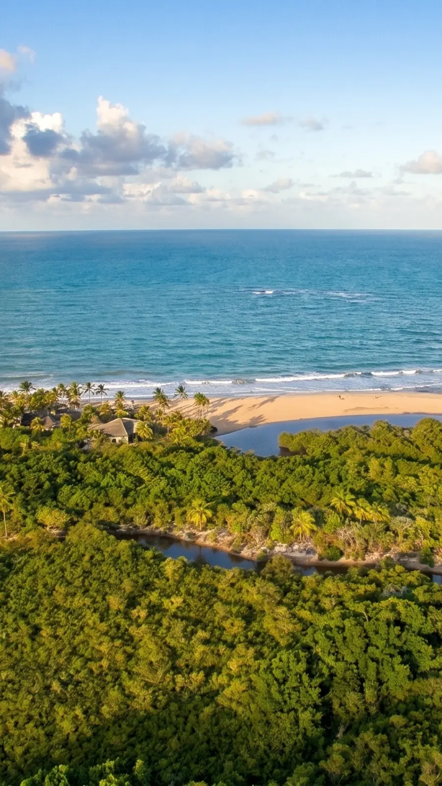 Vista aérea da praia de Trancoso, Bahia, com mar azul-turquesa, restinga verde e o encontro com o rio